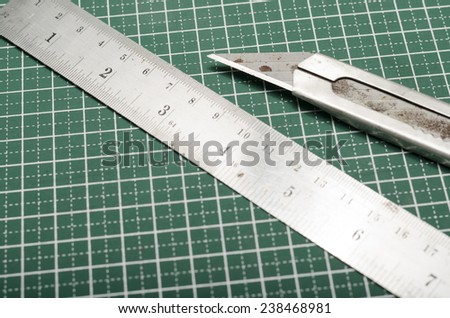 ruler and cutter on green cutting mat