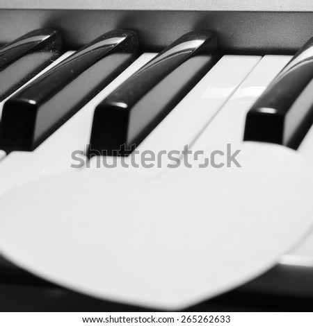 paper heart on piano keyboard black and white color
