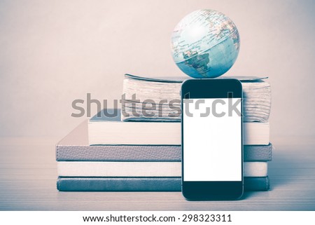 book and earth ball with smart phone on wood background vintage style