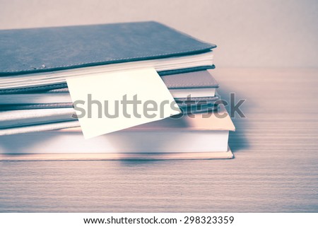 stack of book with sticky note on wood background vintage style