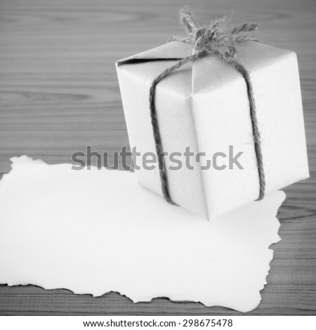 gift box with paper write your note on wood background black and white color tone style
