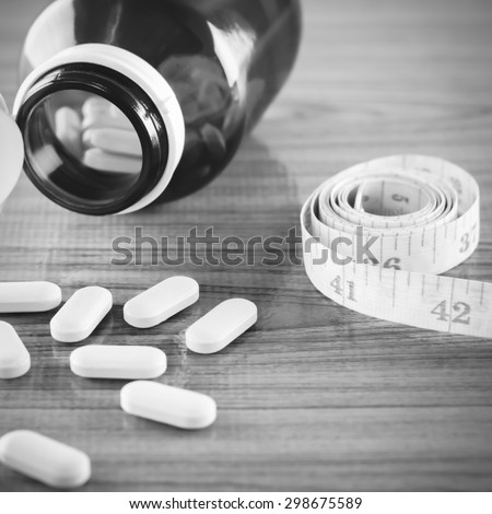 pills and measuring tape concept diet with drug black and white color tone style