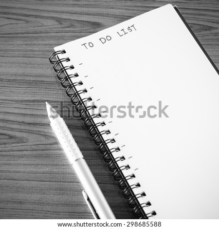 notebook and pen with word to do list on wood background black and white color tone style