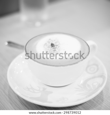 hot cappuccino on wood table black and white color tone style