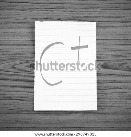 grade c plus on wood wall background black and white color tone style