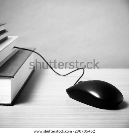 book and computer mouse on wood background black and white color tone style