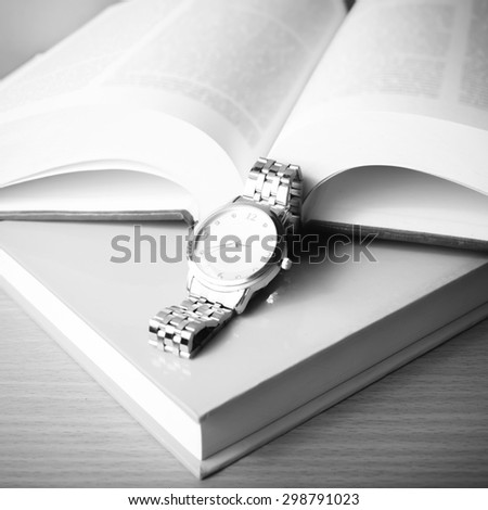 book with watch on wood background black and white color tone style