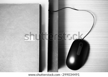 book and computer mouse on wood background black and white color tone style