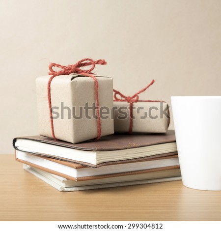 book with gift box and coffee mug on wood background