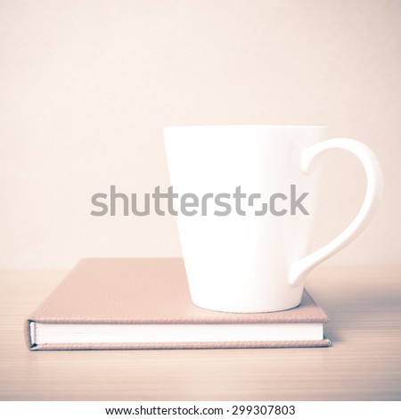 book and coffee mug on wood background vintage style