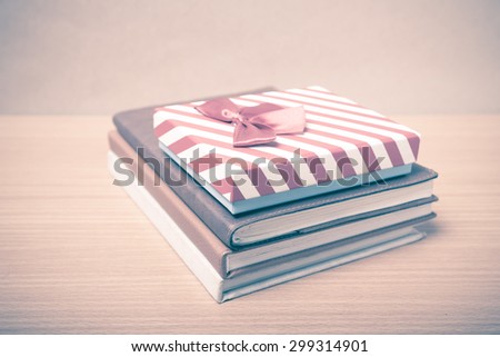 book with gift box on wood background vintage style