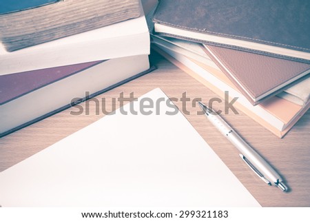 empty paper and pen with book on wood background vintage style