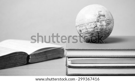 book and earth ball on wood background black and white color tone style