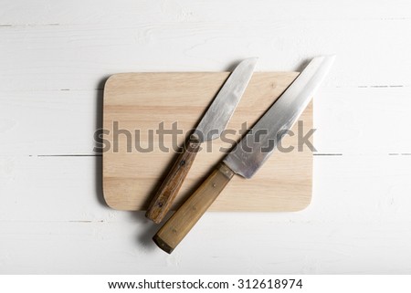 kitchen knife on cutting board over white table background