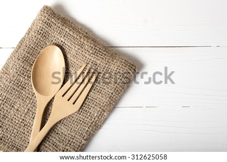 wood spoon and fork on kitchen towel over white background