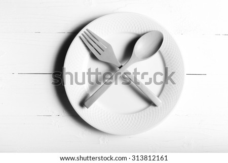 wood spoon and fork with dish over table background black and white tone color style