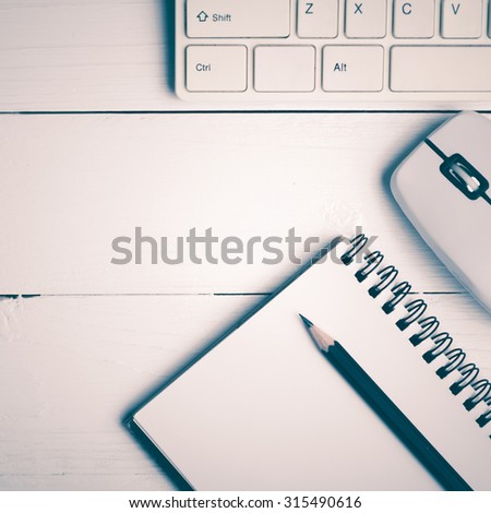 notepad and computer on white table background view from above vintage style