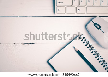 notepad and computer on white table background view from above vintage style