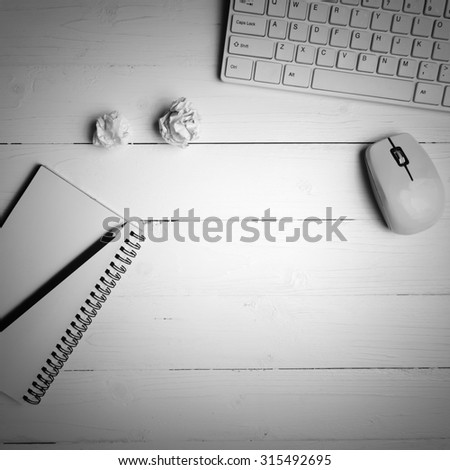 notepad and computer on white table background view from above black and white color style