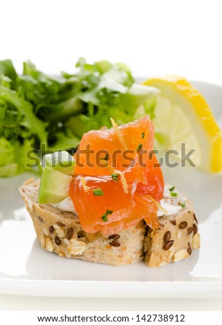 Canapes with smoked salmon, cream cheese and avocado cubes