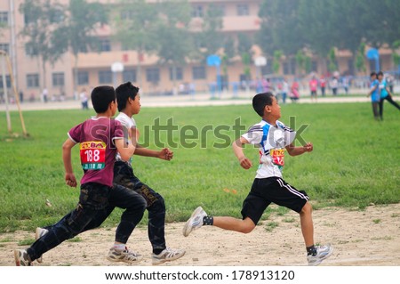 BAIXIANG COUNTY, HEBEI PROVINCE, CHINA - MAY 10, 2013: Baixiang County Middle School Track Meet held. Unidentified student athletes struggling to compete in a race against the project.