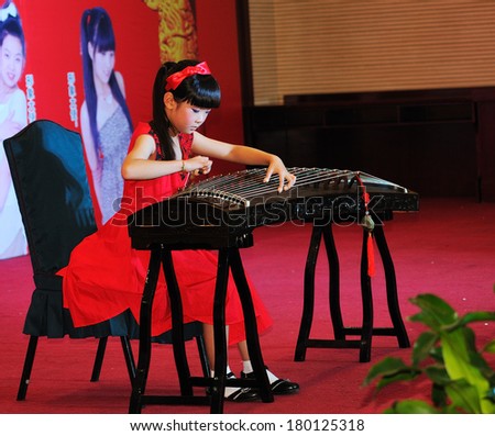 Shijiazhuang City, Hebei Province, China July 7: On July 7, 2012 in Hebei Province, China Youth Arts Festival Area, an unidentified girl ecstatic playing traditional Chinese instruments, the guqin.