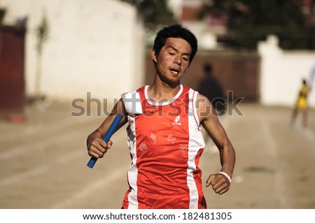 Xingtai City, China - May 12: In May 12, 2011, baixiang County Middle School Games were held. Unidentified student athletes in the four-way one hundred worked hard to win the game.
