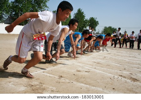 BAIXING COUNTY, CHINA - MAY 12, 2011: Baixiang County Middle School Track Meet held in May 12, 2011. Unidentified student athletes struggling after hearing the starting signal toward the front.