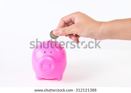 A man\'s hand handle money to pink piggy bank