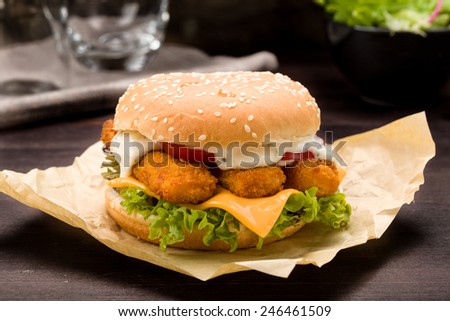 Burger with fish fingers fresh lettuce, tomato and tartar sauce