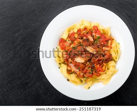 Ribbon pasta with chicken and tomato leek sauce topped with chives