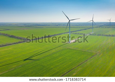 Similar – Image, Stock Photo Long shadow under windmill, large wind power turbines spinning to generating clean, green, renewable energy