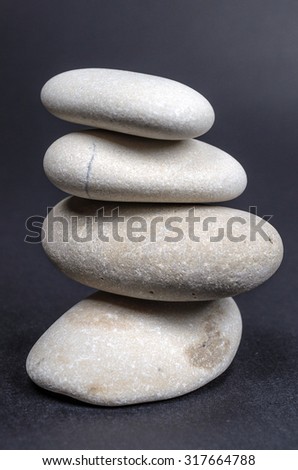 Tower of river stones isolated on black