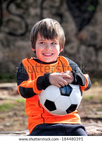 Boy with football soccer / shirt and ball in a park