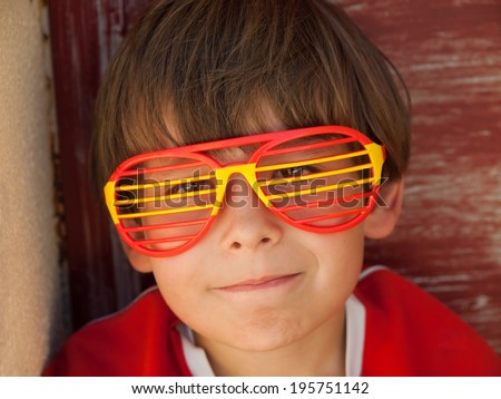 young boy with  funny fan glasses and scarf supports the spanish soccer / football team