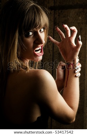 Angry female vampire slitting her wrist. Taken in an old Viennese cellar.
