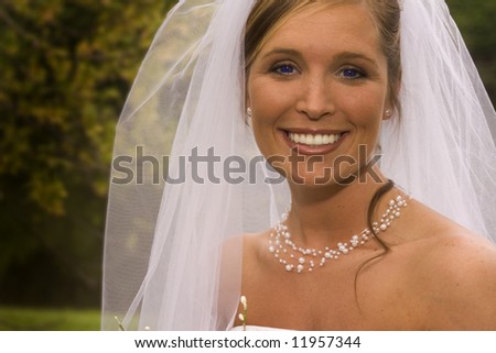 Young female bride to be wearing her vail and wedding dress