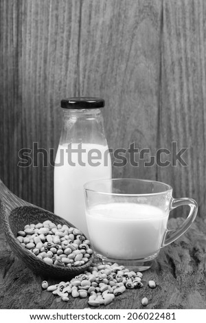 Soy beans and soy milk in a glass cup. Black and white image.