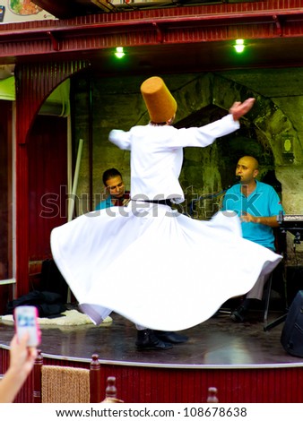 ISTANBUL - JULY 25: Sufi whirling dervish (Semazen) dances at Sultanahmet during month of Ramadan on July 25, 2012 in Istanbul. Semazen conveys God\'s spiritual gift to those are witnessing the ritual.