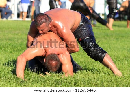 ISTANBUL - AUGUST 24: Unidentified wrestlers in the 8th Sile Annual Oil Wrestling Event on August 24, 2012 in Istanbul. Close up of oil wrestlers (Pehlivan) in a tight grip.