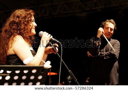 ISTANBUL - JULY 11: Members of the Maltepe Symphonic Orchestra perform live at Maltepe open air stage on July 11, 2010 in Istanbul. Soprano Selva Erdener with conductor Naci Ozguc