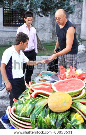 ISTANBUL - AUGUST 31: People buy and eat fruits from street vendors during Lesser Bairam at Sultanahmet on August 31, 2011 in Istanbul, Turkey. In Ramadan Month temperature was over 35 degree Celsius.