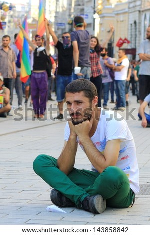 ISTANBUL - JUN 17: Labor unions call 1-day nationwide strike over crackdown on June 17, 2013 in Istanbul, Turkey. A young man sits down in protest as demonstrating police brutality.