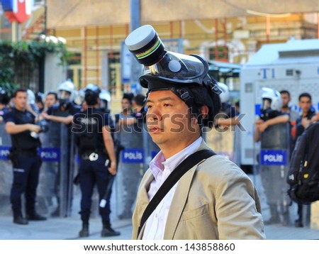 ISTANBUL - JUN 17: Five labor unions call 1-day nationwide strike over crackdown on June 17, 2013 in Istanbul, Turkey. A journalist wearing gas-mask to protect from pepper gas at Istiklal Street