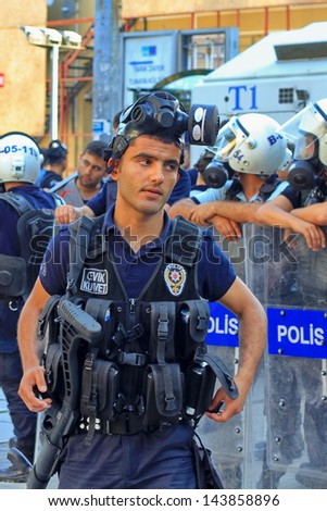 ISTANBUL - JUN 17: Five labor unions call 1-day nationwide strike over crackdown on June 17, 2013 in Istanbul, Turkey. A policeman wearing full equipment belt waits on Istiklal Street.