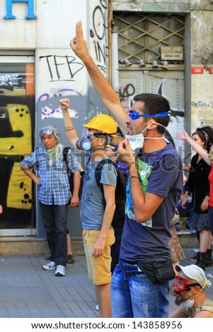 ISTANBUL - JUN 17: Labor unions call 1-day nationwide strike over crackdown on June 17, 2013 in Istanbul, Turkey. Demonstrators wearing gas-mask makes victory sign against police during the portest.