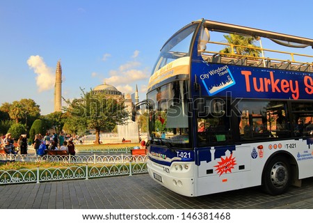 ISTANBUL - JUL 15: Sight seeing tourist bus in front of Hagia Sophia on July 15, 2013 in Istanbul. Sultanahmet Square one of the most popular travel destination in Turkey. Turkey Travel