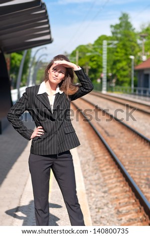 girl standing at the bus stop and waiting for the train