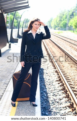 girl standing at the bus stop and waiting for the train