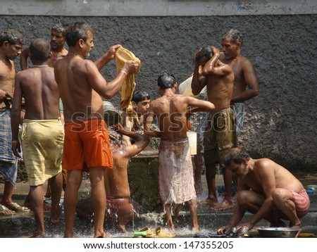 KOLKATA, WEST BENGAL, INDIA - MARCH 11: Unidentified men and boys wash at a street water tank on March 11, 2010  in Kolkata (Calcutta), India.  Hygiene and cleanliness is of great importance in India.